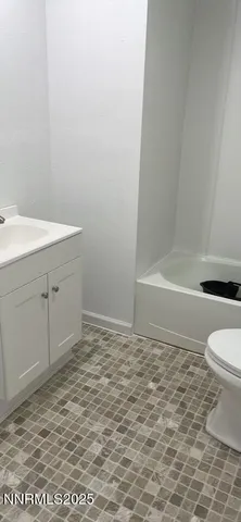 a white toilet sitting next to a bath tub