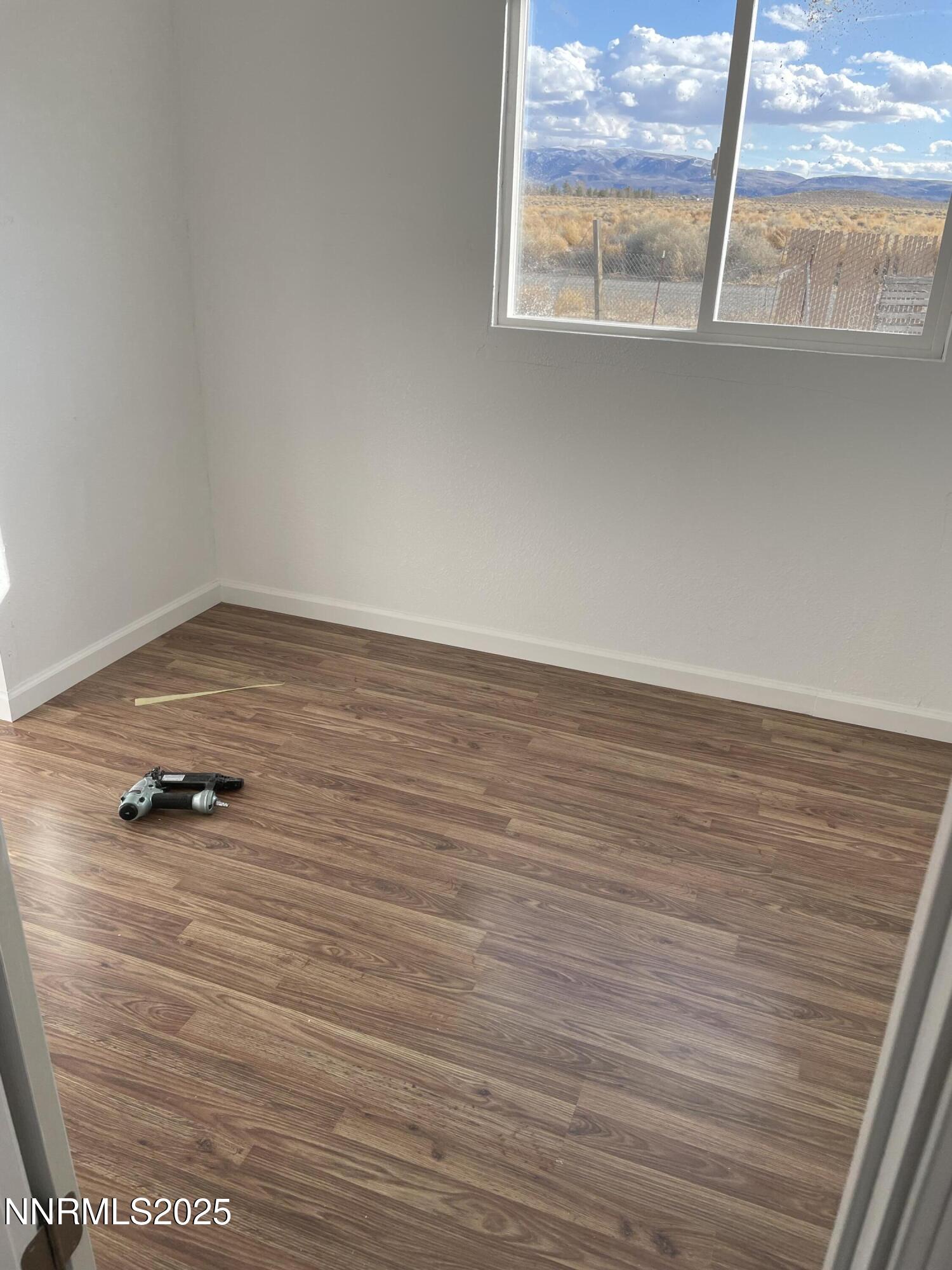 2725 East Fir Street Silver Springs, NV 89429 - Photo 51 of 56 a view of empty room with wooden floor and window