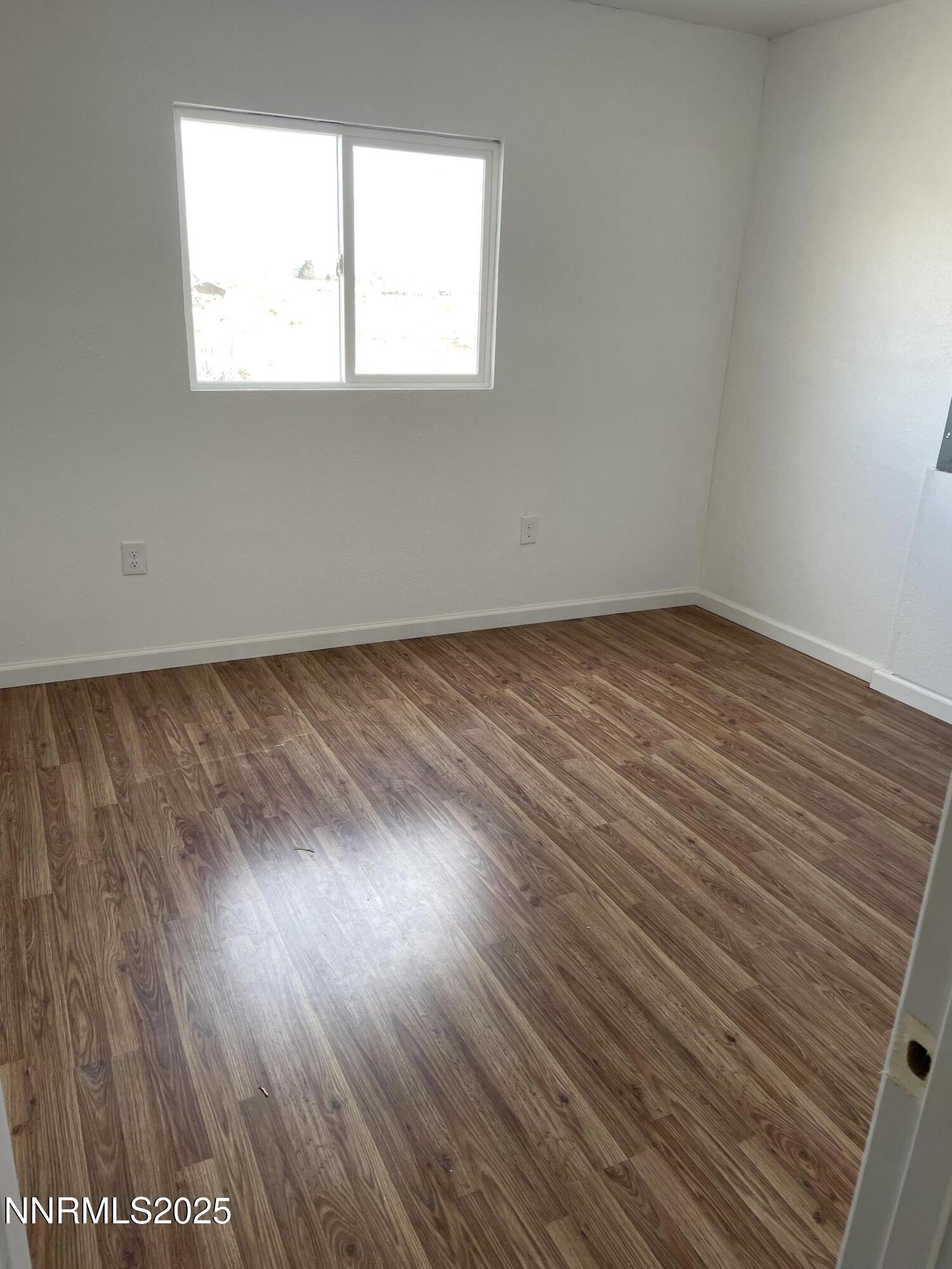 2725 East Fir Street Silver Springs, NV 89429 - Photo 54 of 56 an empty room with wooden floor and windows
