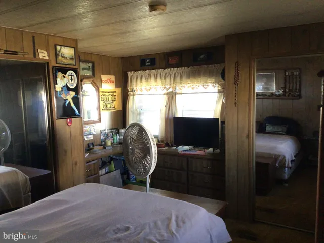 a bedroom with a bed and large mirror