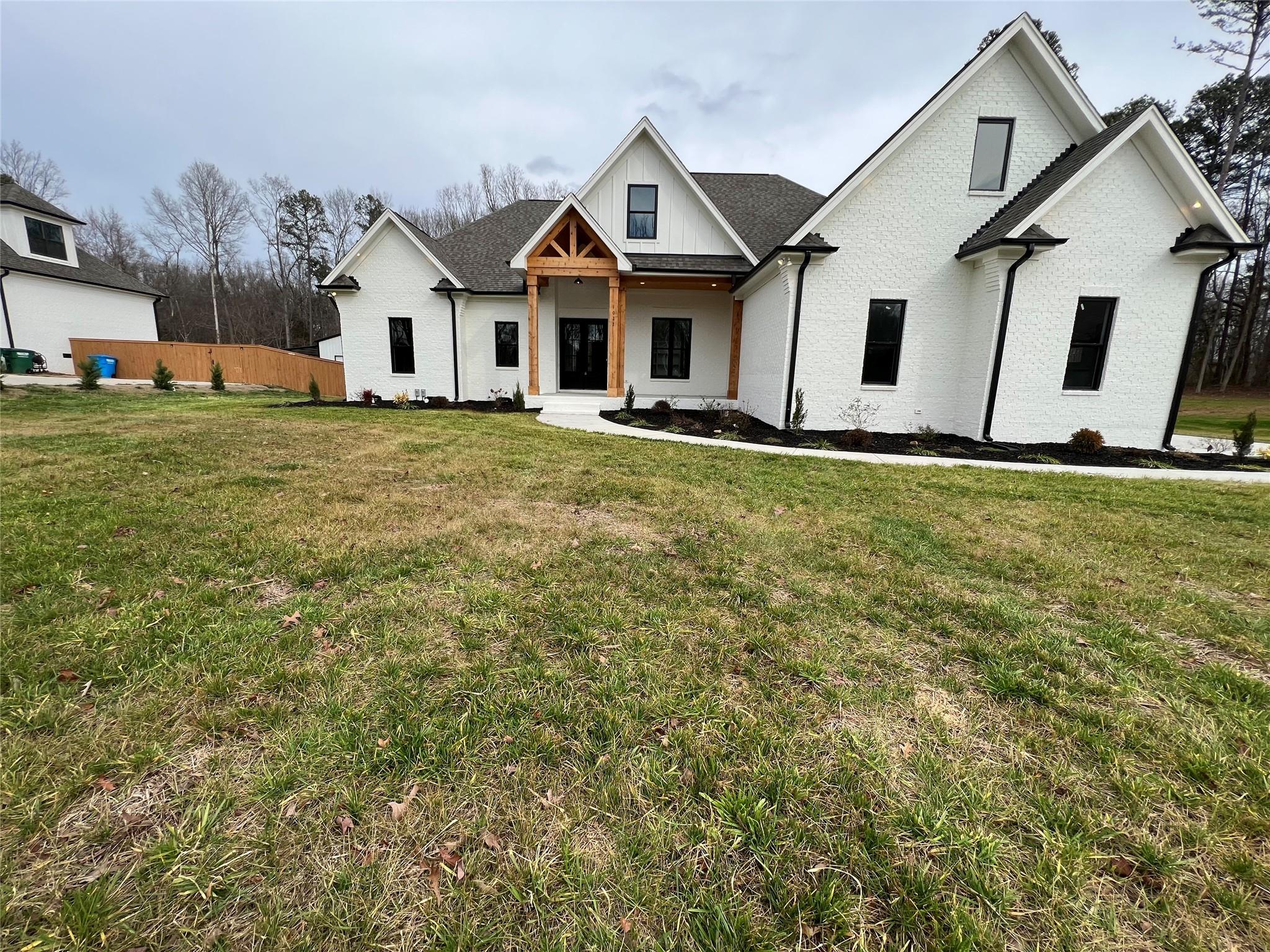 1022 Piney Drive Monroe, NC 28110 - Photo 3 of 48 a view of a white house next to a yard with big trees