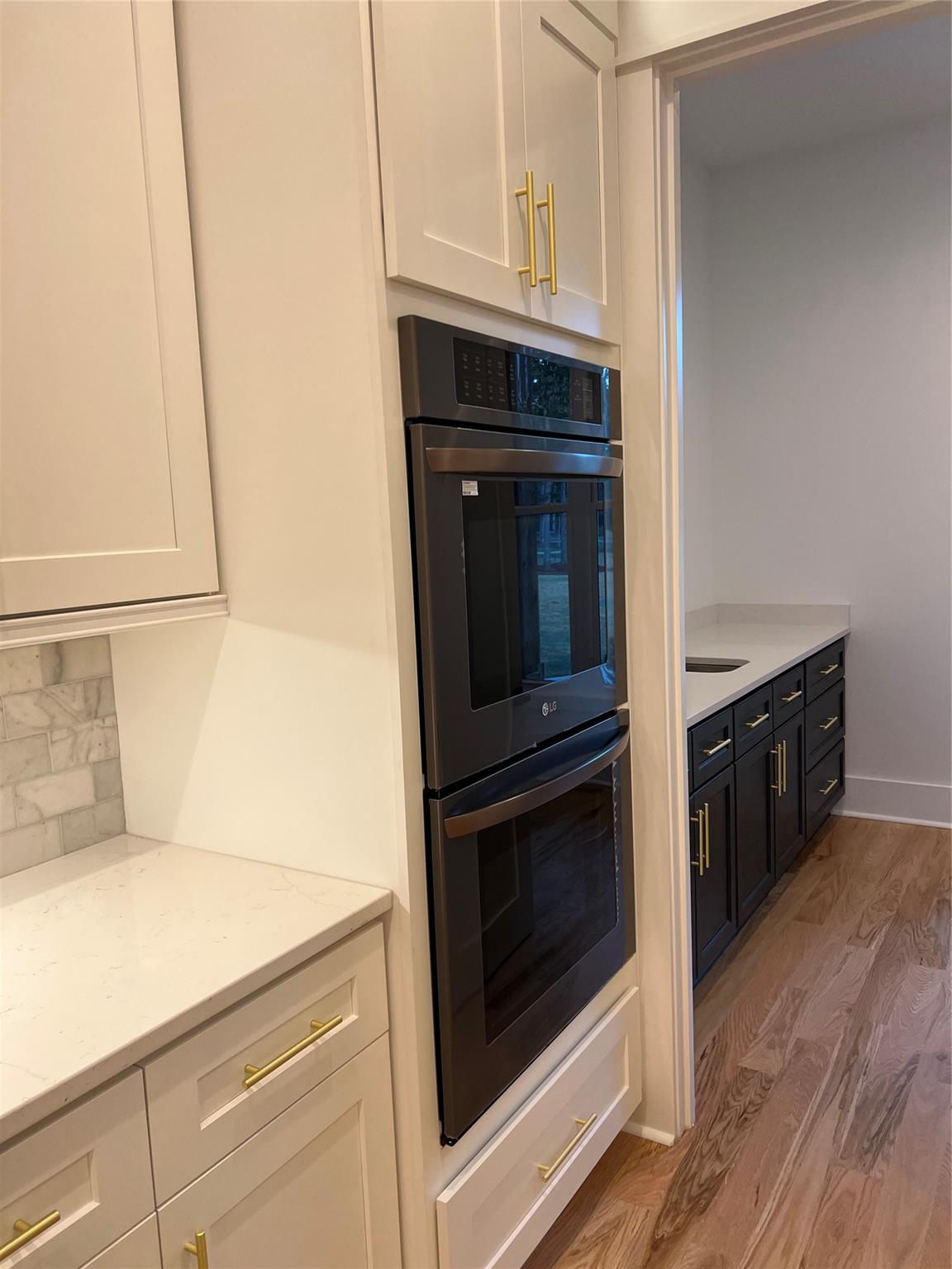 1022 Piney Drive Monroe, NC 28110 - Photo 9 of 48 a kitchen with stainless steel appliances white cabinets and a wooden floor