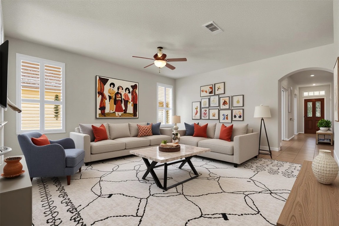 a living room with furniture ceiling fan and a window