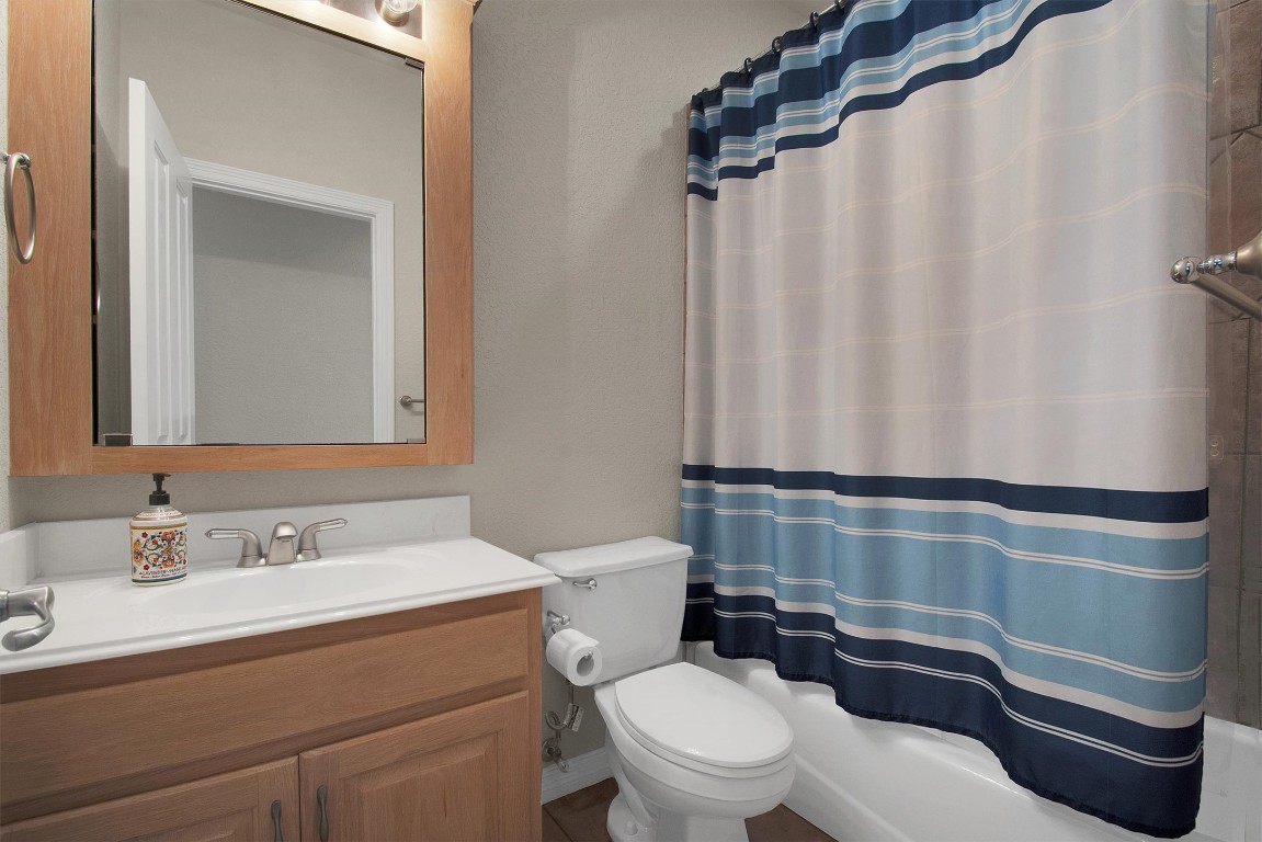 102 Lavaca Lane Georgetown, TX 78628 - Photo 18 of 23 a bathroom with a toilet a sink and a mirror