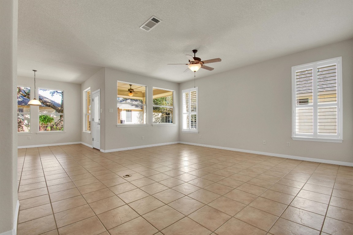 102 Lavaca Lane Georgetown, TX 78628 - Photo 7 of 23 an empty room with windows and chandelier fan