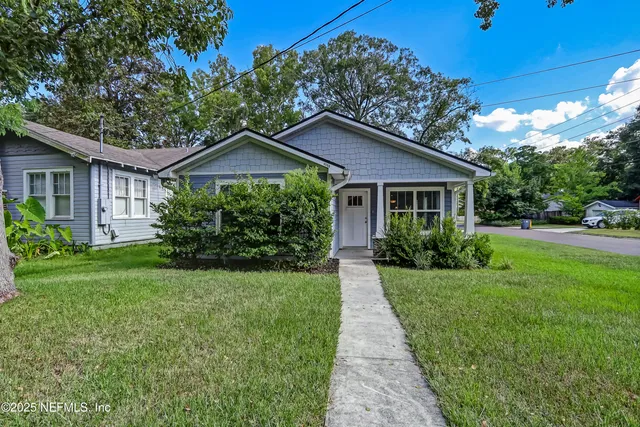 a front view of a house with yard and green space