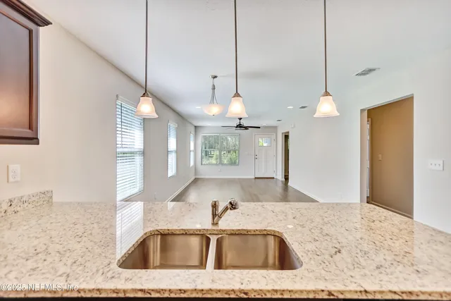 a kitchen with a sink a center island and a chandelier