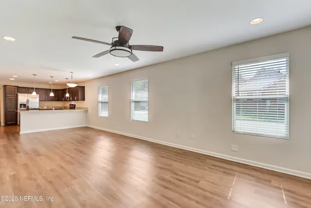 a view of a kitchen with wooden floor and windows