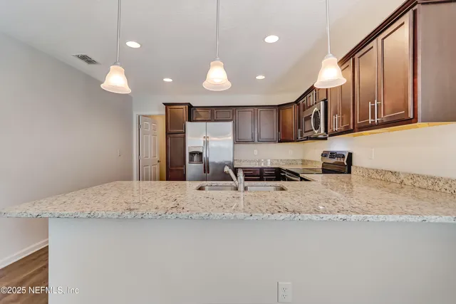 a large kitchen with kitchen island a sink stainless steel appliances and a counter top space