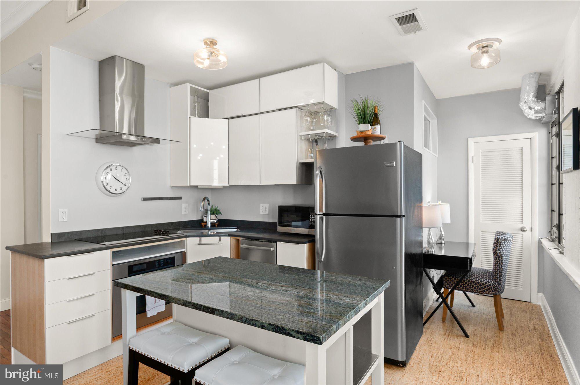 1701 16th Street Northwest, Unit 802 Washington, DC 20009 - Photo 9 of 33 a kitchen with stainless steel appliances granite countertop a sink refrigerator and microwave
