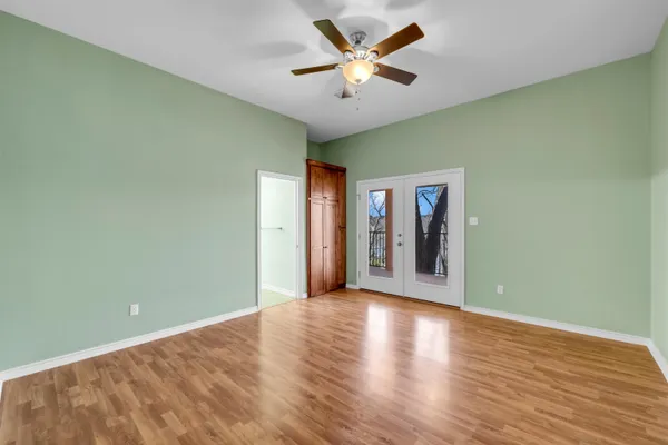 a view of a big room with wooden floor and a ceiling fan