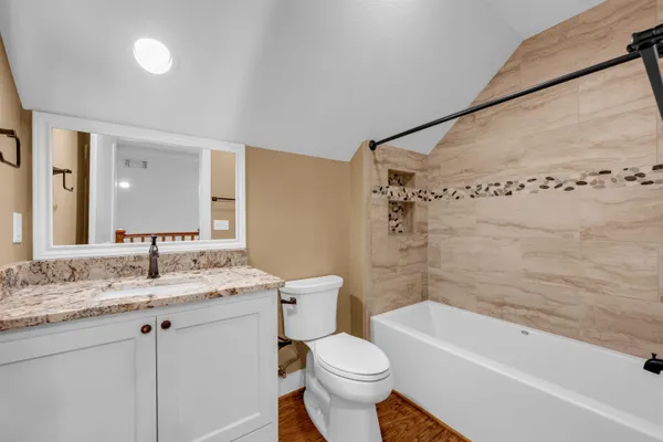 a bathroom with a sink toilet vanity and bathtub