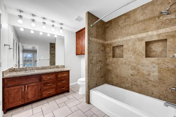 a bathroom with a tub sink shower and mirror