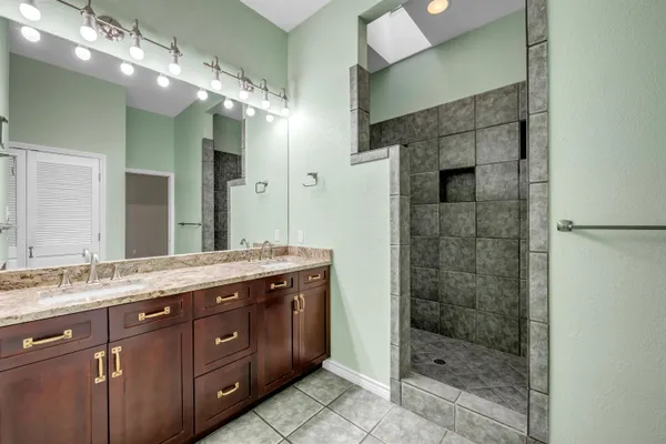 a spacious bathroom with a shower sink and mirror