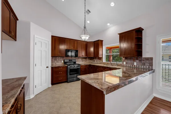 a kitchen with granite countertop stainless steel appliances and wooden cabinets