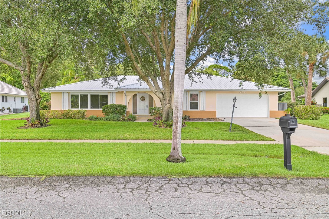 a front view of a house with a yard and trees