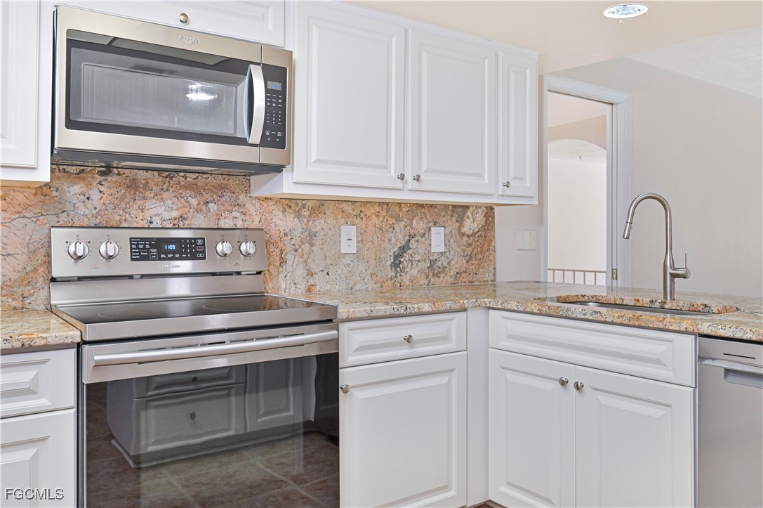 4255 Glasgow Court North Fort Myers, FL 33903 - Photo 12 of 35 a kitchen with white cabinets stainless steel appliances and sink