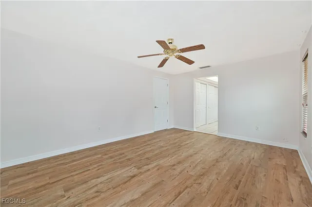 a view of empty room with wooden floor
