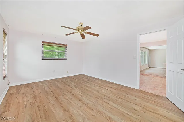 a view of empty room with wooden floor and fan