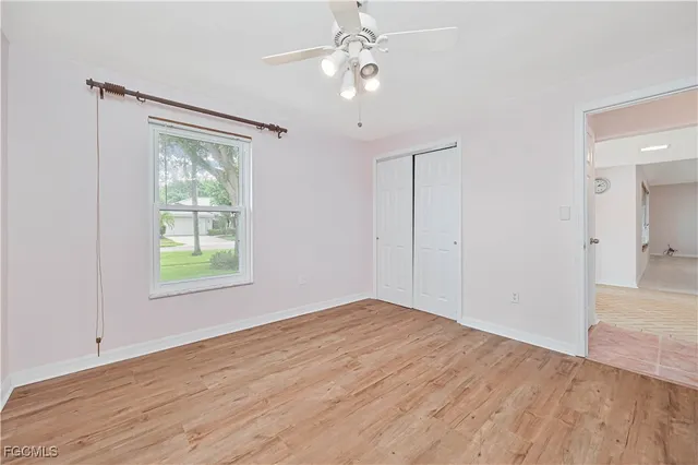 an empty room with fan and windows