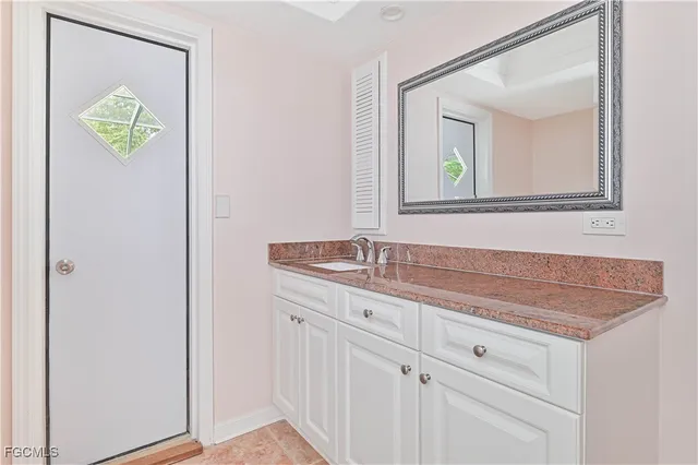 a bathroom with a granite countertop sink a toilet and a mirror