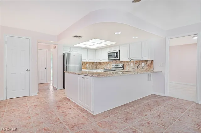 a kitchen with stainless steel appliances granite countertop a refrigerator sink and cabinets