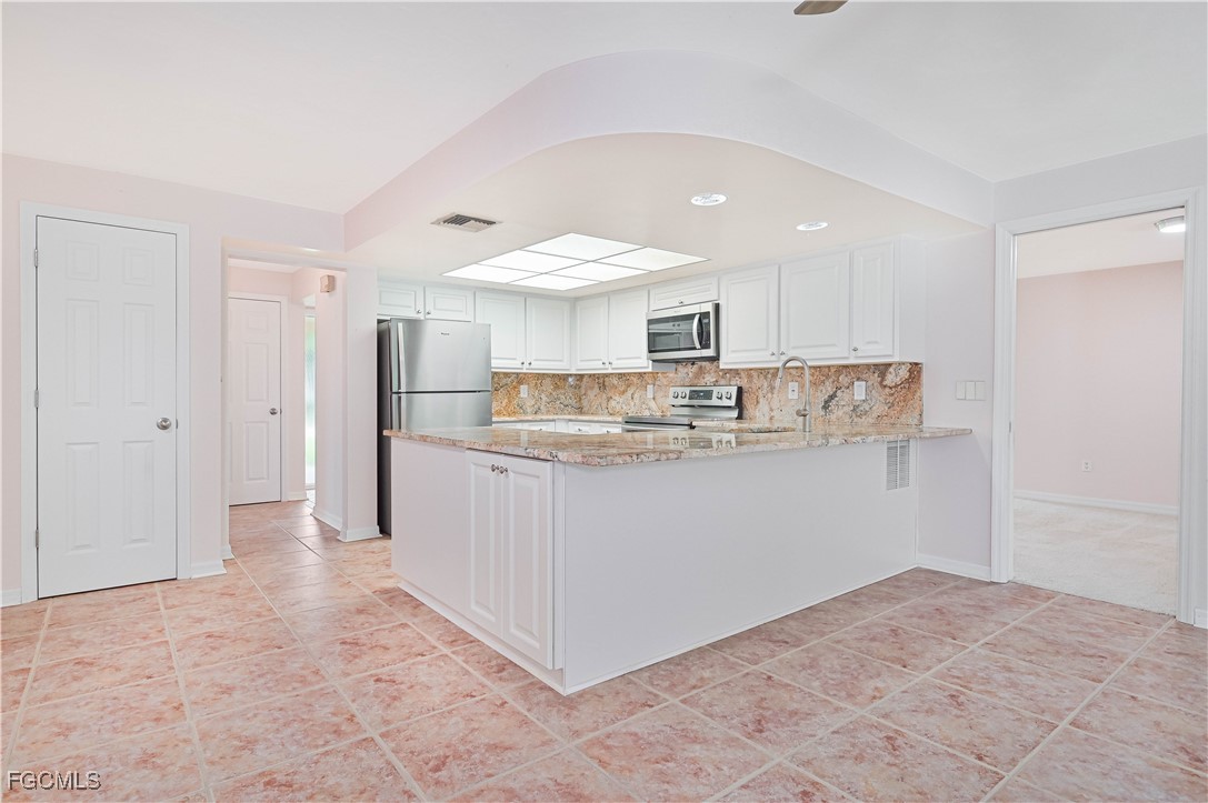 4255 Glasgow Court North Fort Myers, FL 33903 - Photo 10 of 35 a kitchen with stainless steel appliances granite countertop a refrigerator sink and cabinets