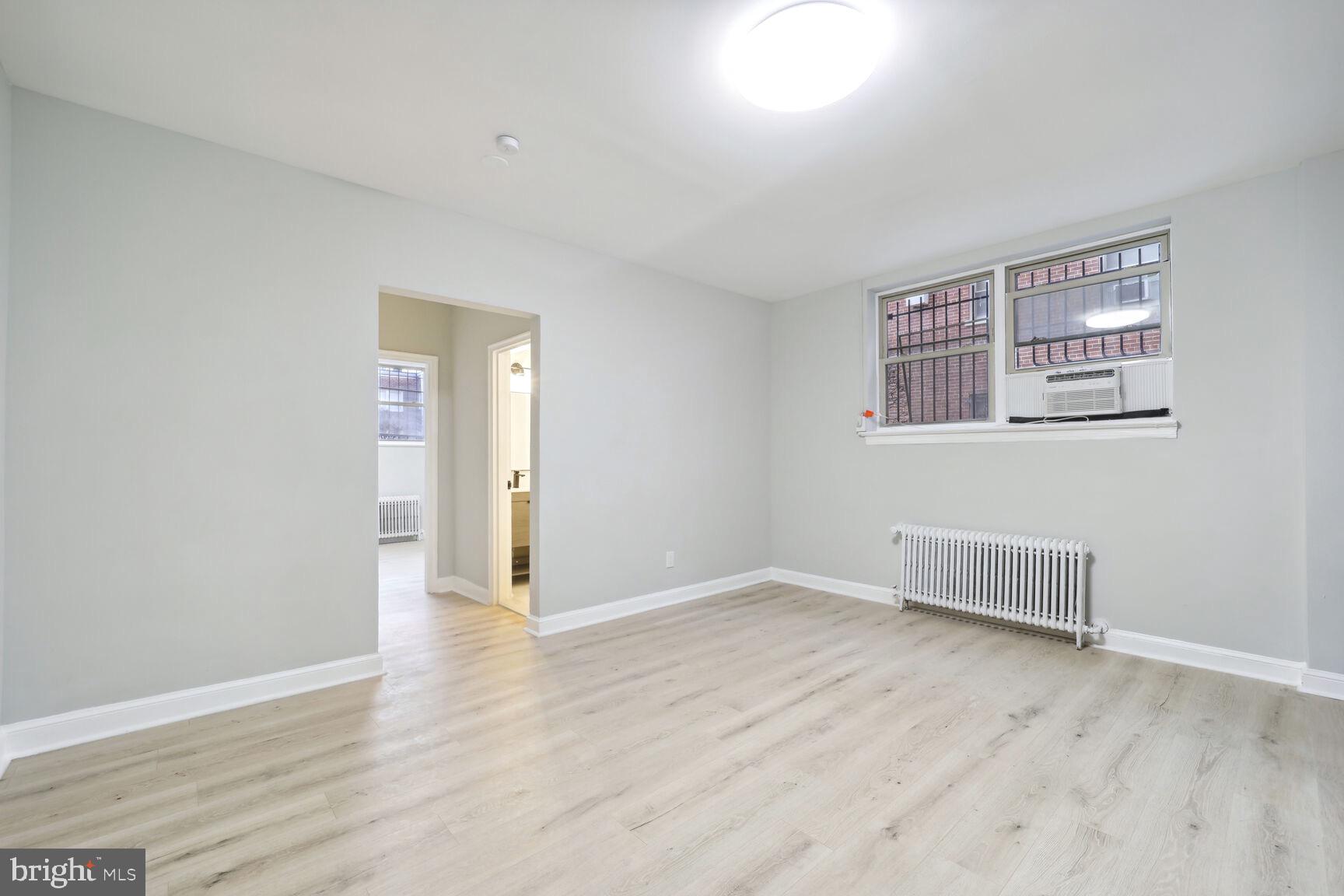 3937 S Street Southeast, Unit 6A Washington, DC 20020 - Photo 2 of 23 an empty room with wooden floor and windows