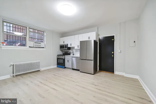 a kitchen with refrigerator cabinets and wooden floor