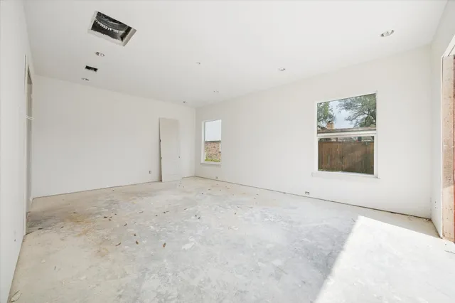 an empty room with windows and closet