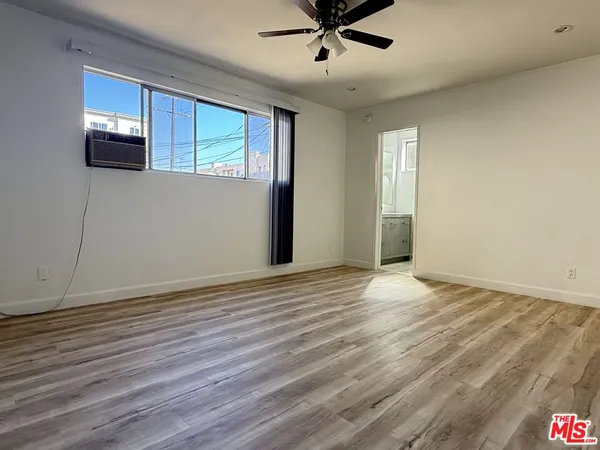a view of a livingroom with wooden floor and a ceiling fan