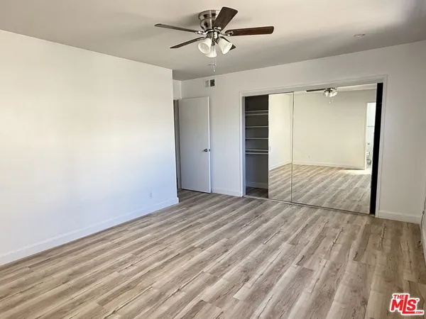a view of a livingroom with wooden floor and a ceiling fan