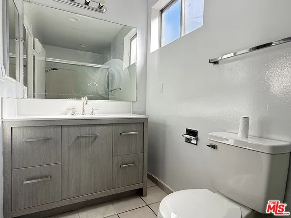 a bathroom with a sink vanity mirror and toilet