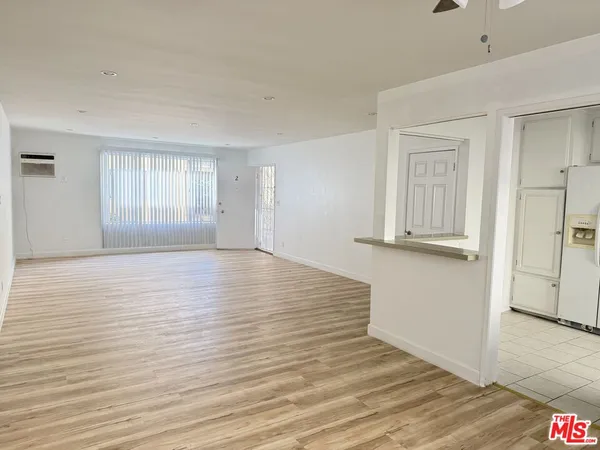 a view of empty room with wooden floor and window