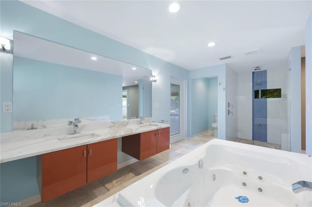 5175 Green Boulevard Naples, FL 34116 - Photo 14 of 43 a spacious bathroom with a bathtub sink and mirror