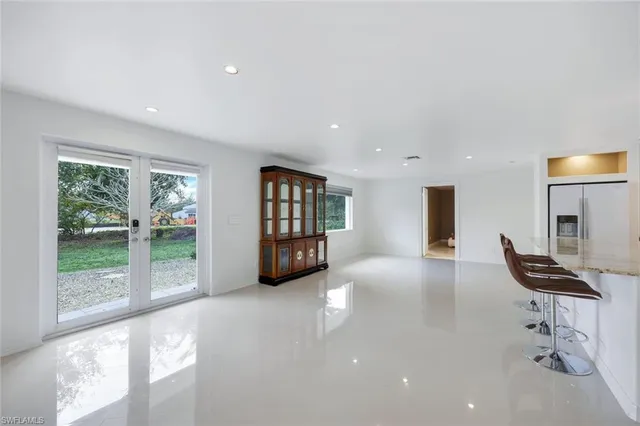 a view of an empty room with furniture and a window