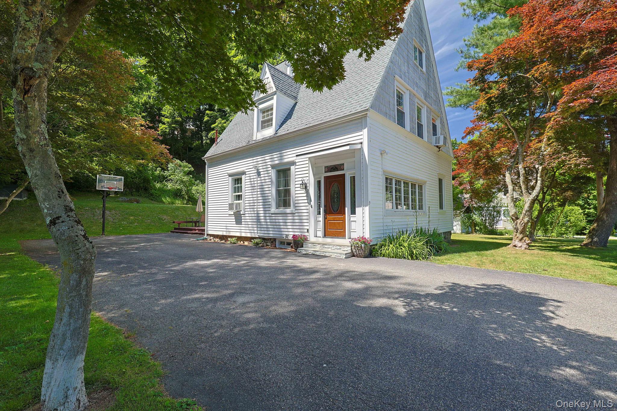 9 Library Road Tuxedo Park, NY 10987 - Photo 2 of 37 White clapboard exterior with a steep-pitched roofline and dormer windows/expansive driveway
