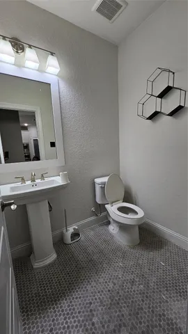 a bathroom with a toilet a sink and mirror