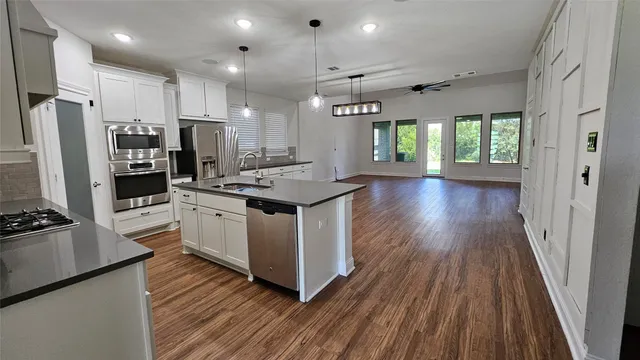 a kitchen that has a lot of counter space and a wooden floor