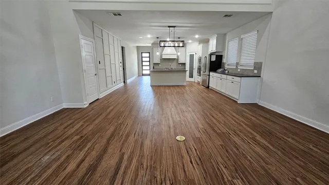 a kitchen with stainless steel appliances wooden floors and view living room