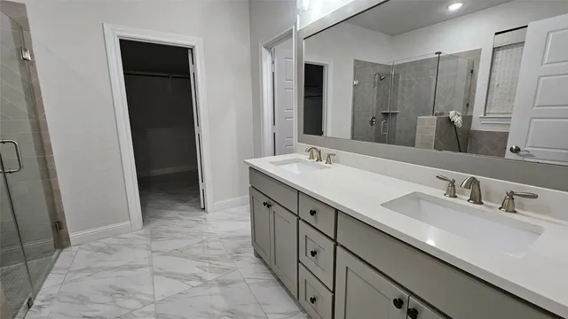 a spacious bathroom with double vanity and a mirror