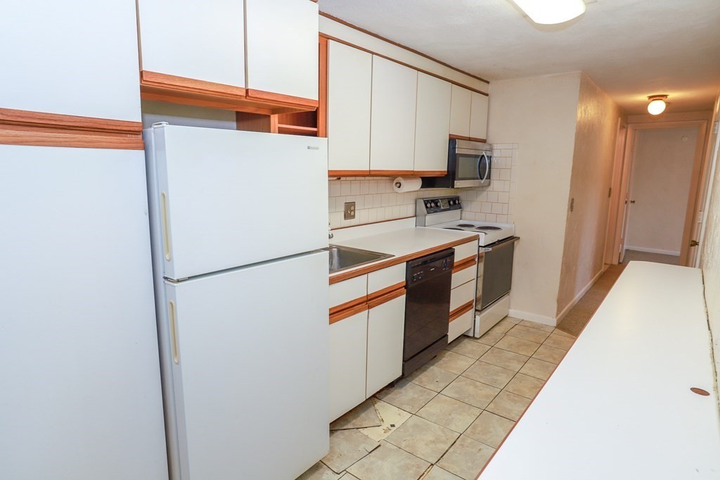 202 Swanson Road, Unit 524 Boxborough, MA 01719 - Photo 5 of 22 a kitchen with stainless steel appliances granite countertop a refrigerator a stove a sink and a microwave