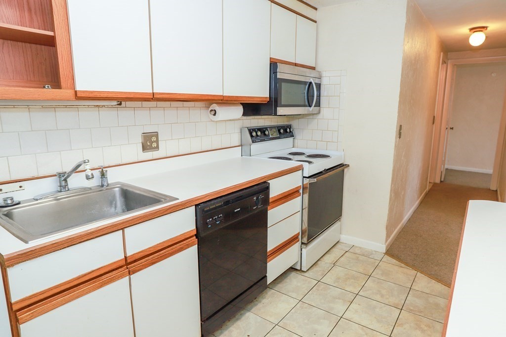 202 Swanson Road, Unit 524 Boxborough, MA 01719 - Photo 6 of 22 a kitchen with stainless steel appliances a sink stove and cabinets
