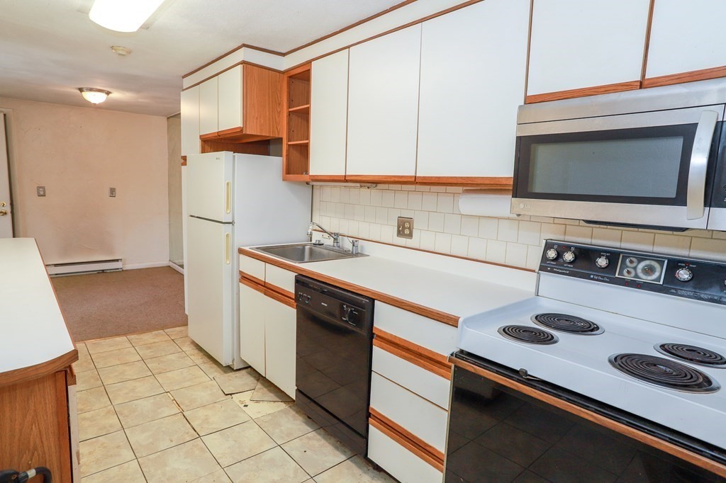 202 Swanson Road, Unit 524 Boxborough, MA 01719 - Photo 8 of 22 a kitchen with a sink a stove and a microwave