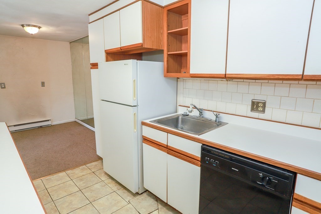 202 Swanson Road, Unit 524 Boxborough, MA 01719 - Photo 9 of 22 a white refrigerator freezer sitting inside of a kitchen