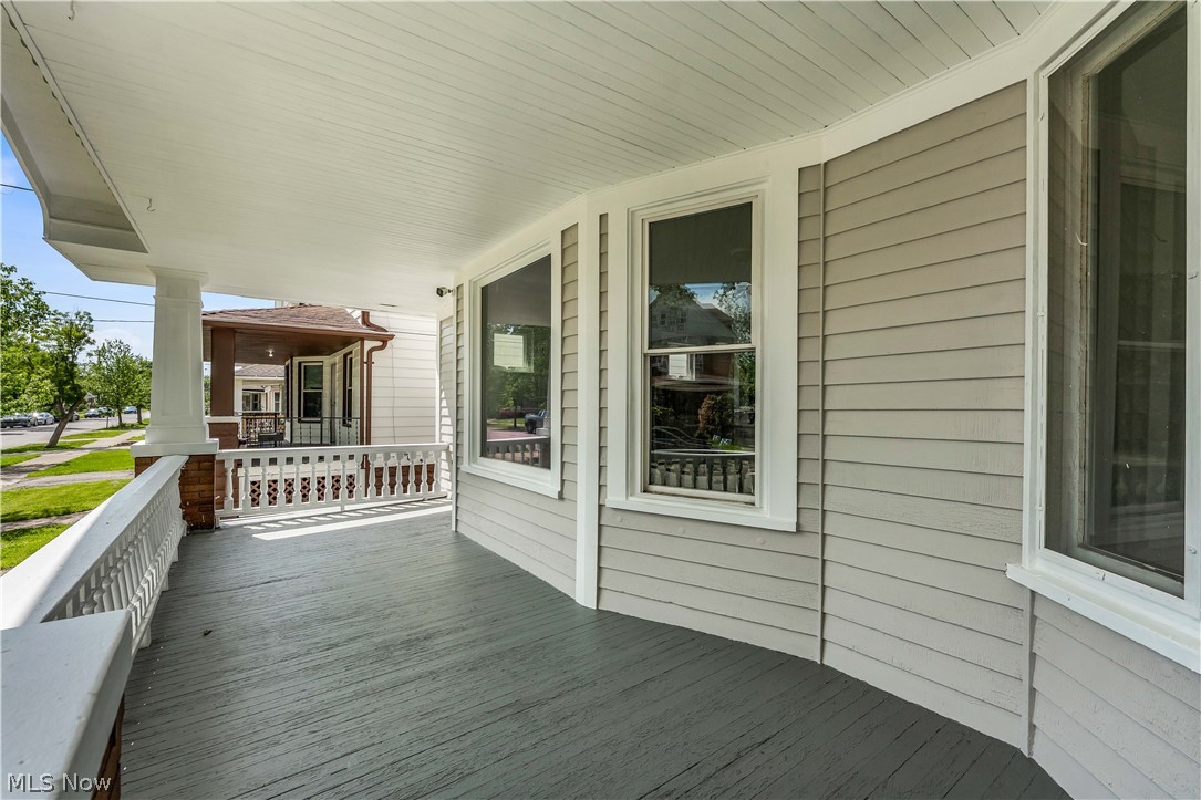 3506 Riverside Avenue Cleveland, OH 44109 - Photo 3 of 31 Expansive covered porch featuring a painted wood floor, white spindle railing, and substantial support columns