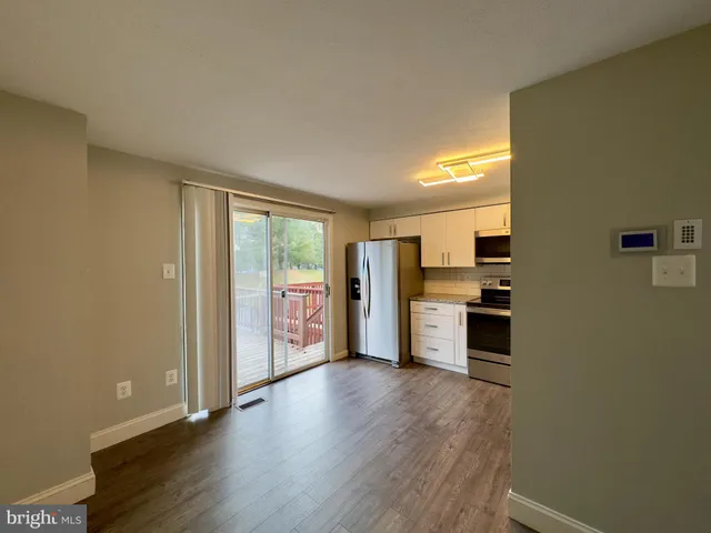 a open kitchen with a sink and dishwasher a stove top oven with wooden floor