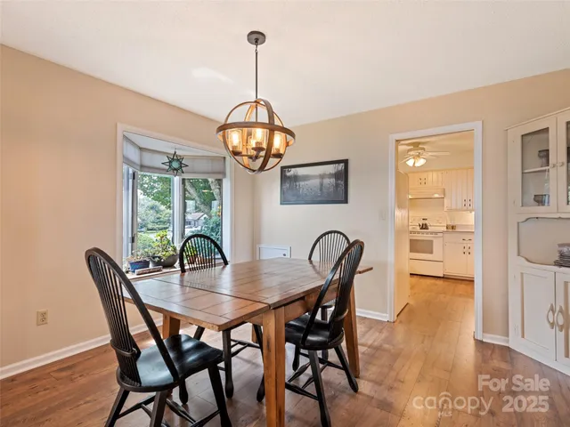 a view of a dining room with furniture a chandelier and wooden floor