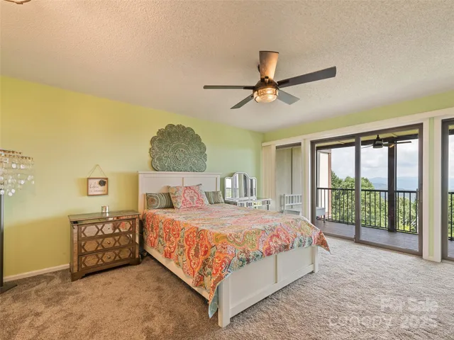a bedroom with a bed a ceiling fan and a large window