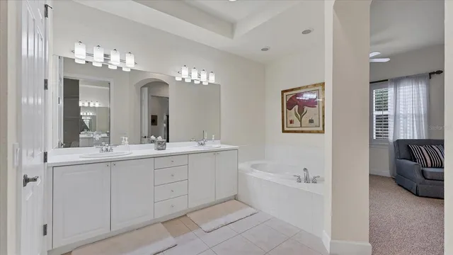 a bathroom with a double vanity sink mirror and bathtub